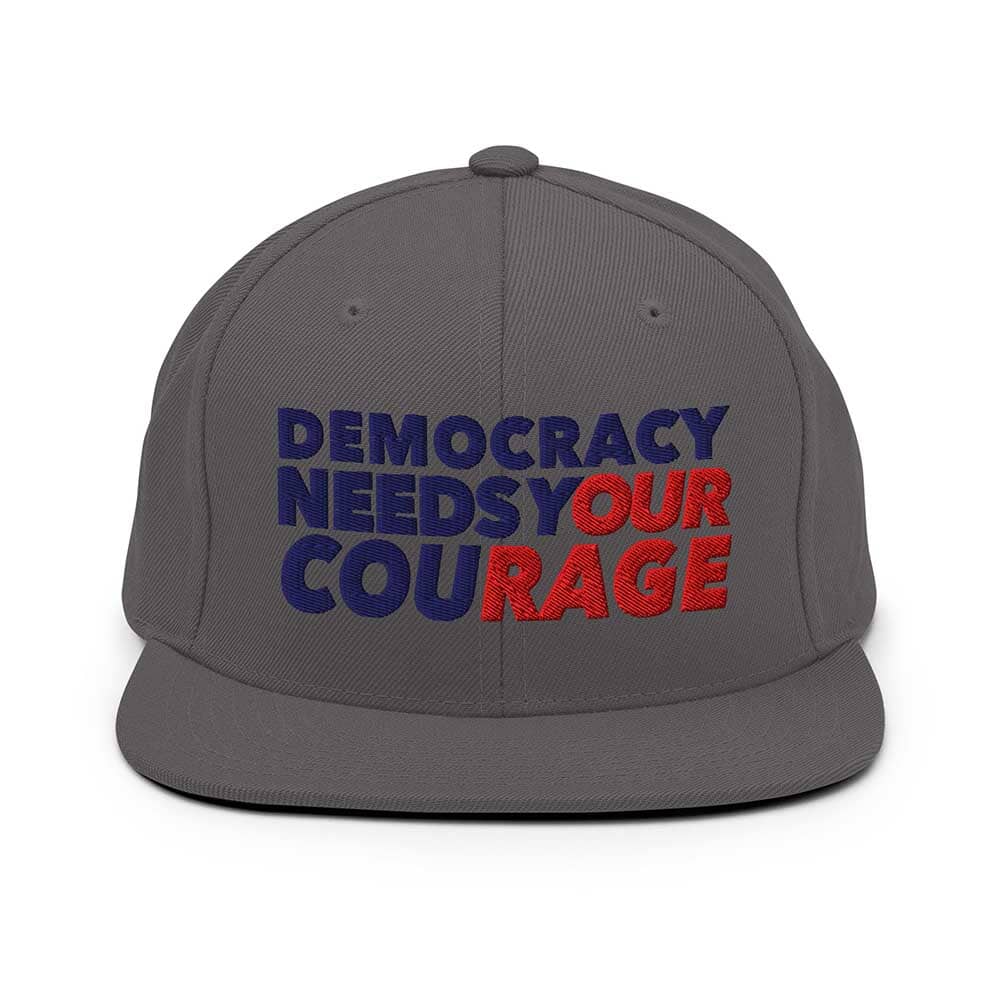 Gray cap with 'Democracy Needs Your Courage' text in blue and red on a white background
