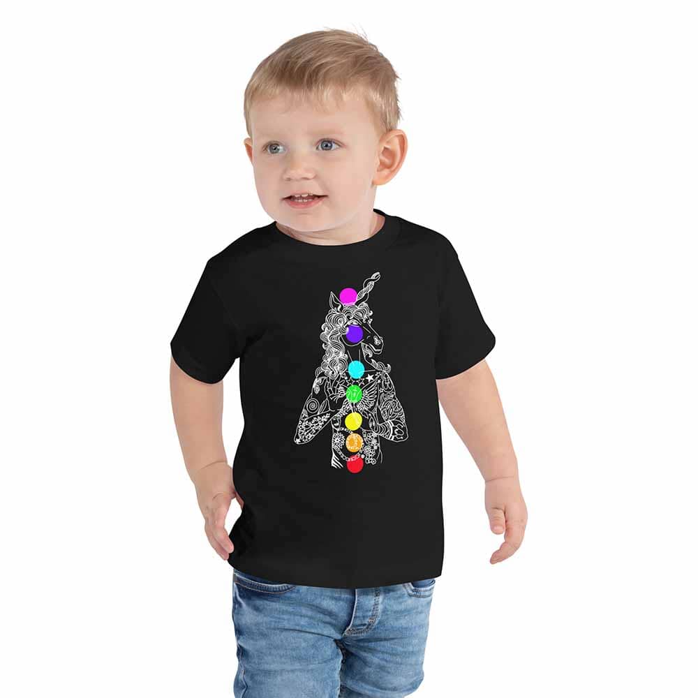Child wearing a black t-shirt with a unicorn chakra graphic design on a white background