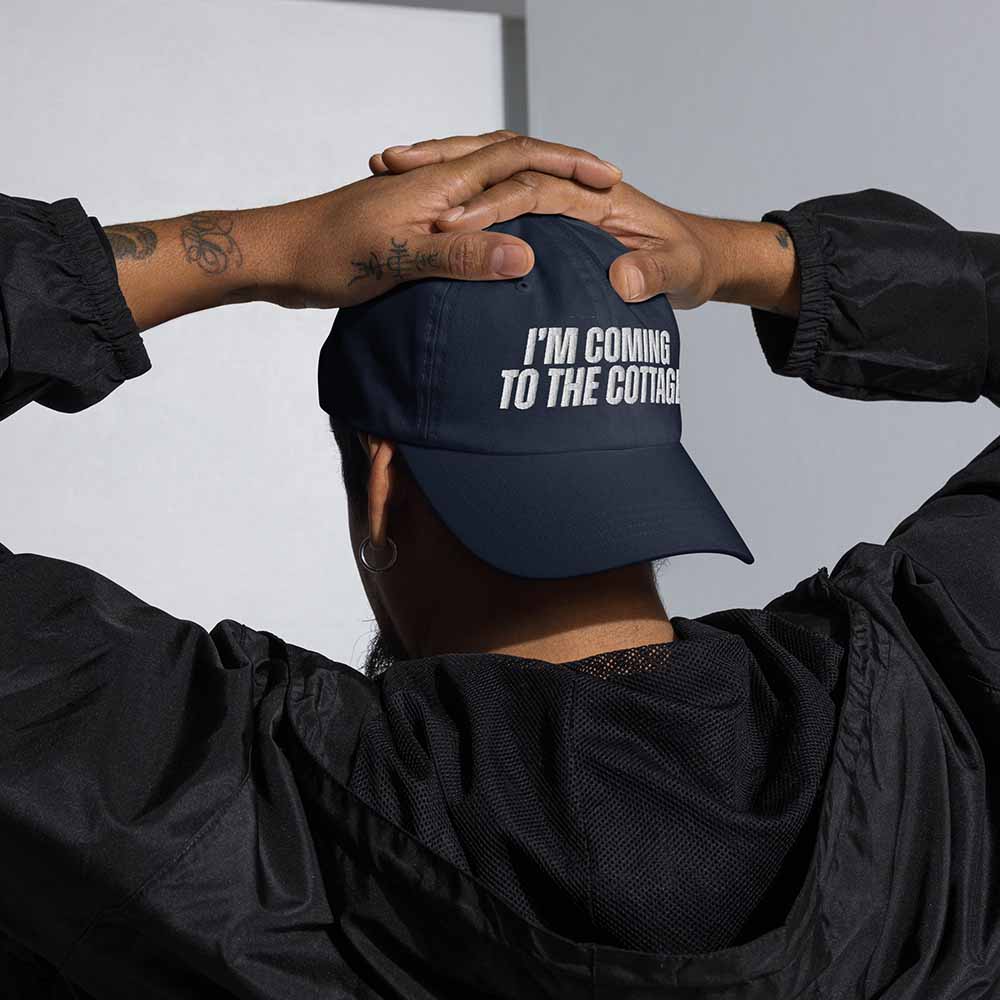 Person wearing a navy blue cap with &