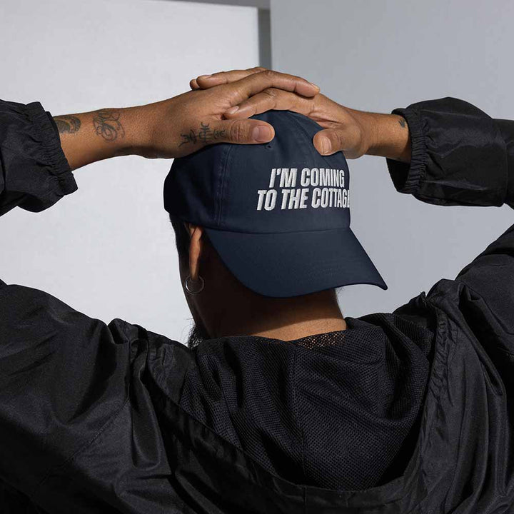 Person wearing a navy blue cap with &