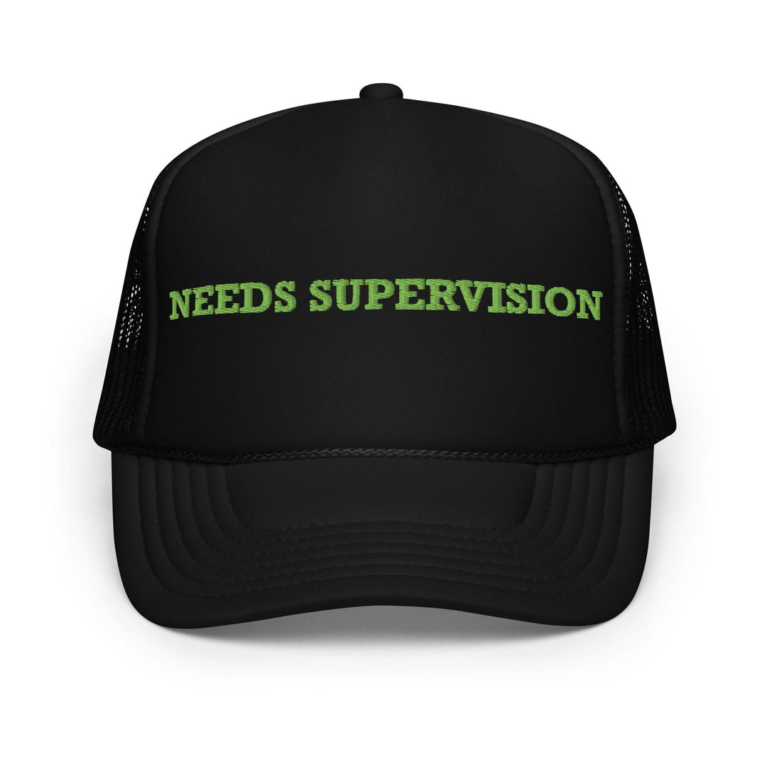 Black cap with 'NEEDS SUPERVISION' text in green on a white background
